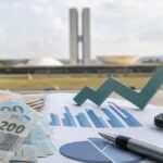 Cédulas de real, calculadora e gráfico sobre o salário mínimo de 2027