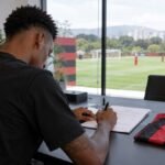 Jogador de futebol assina contrato ao lado de camisa rubro-negra