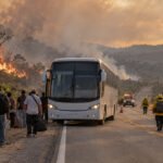 Ônibus parado em rodovia da Bahia durante incêndio na vegetação, com equipes de emergência