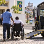 Eleitor em cadeira de rodas embarca em veículo adaptado para transporte eleitoral