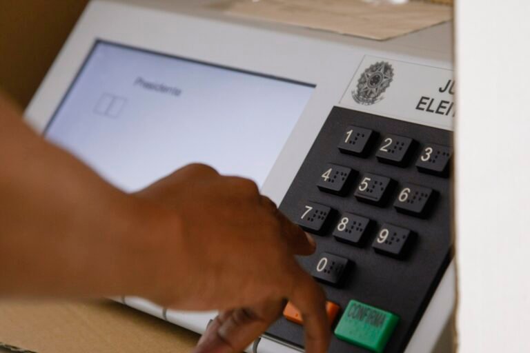 Eleitor votando na urna eletrônica em seção eleitoral
