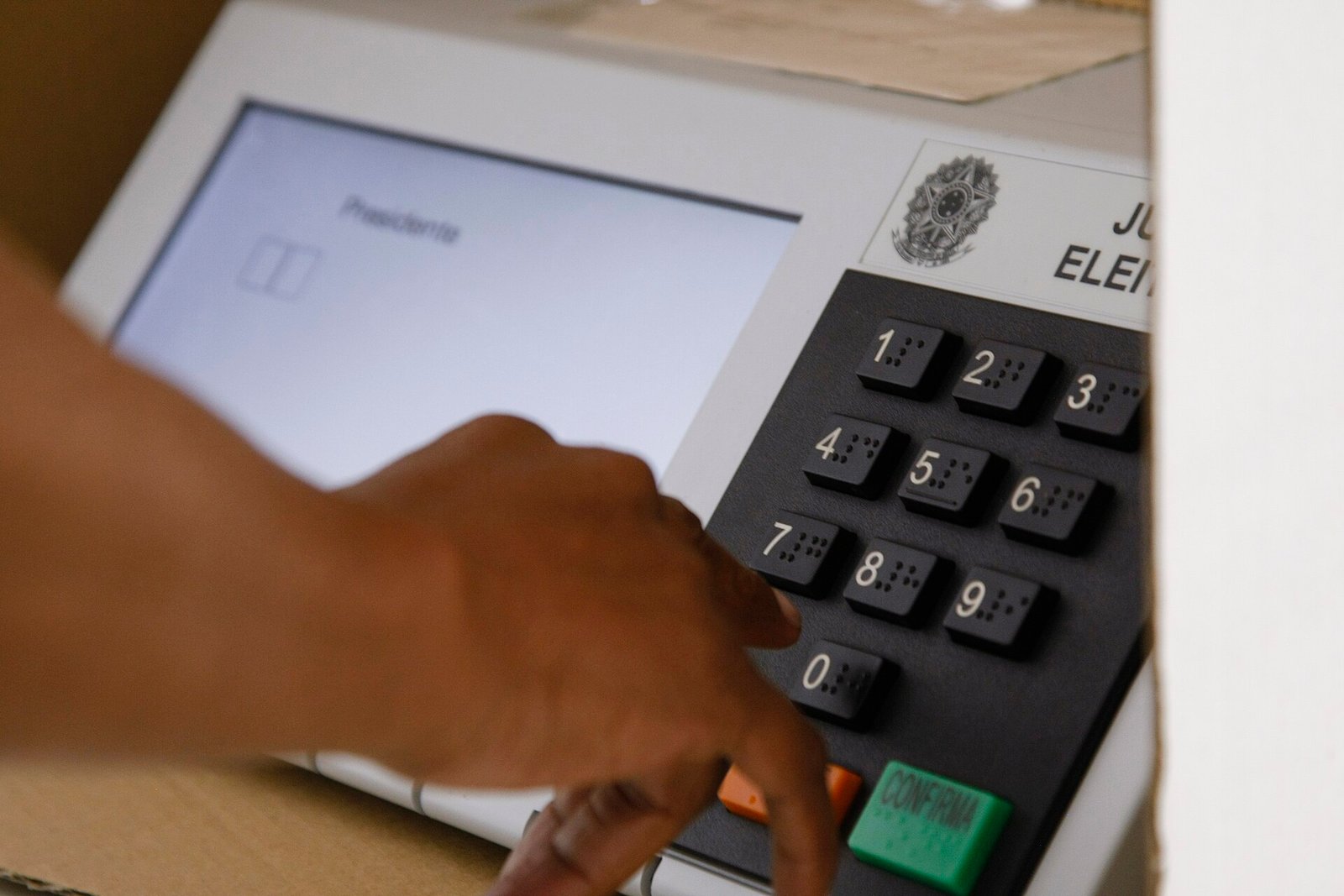 Eleitor votando na urna eletrônica em seção eleitoral