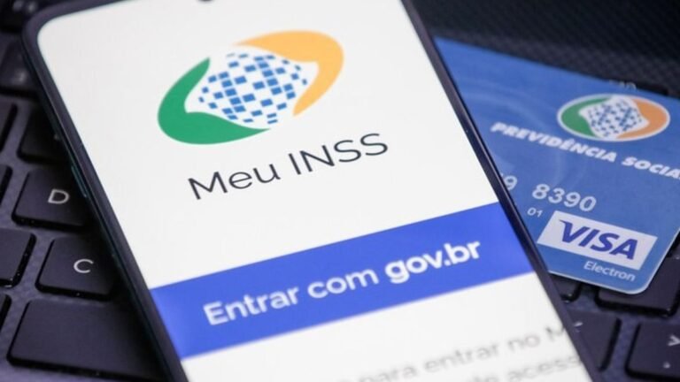 Tela do aplicativo Meu INSS em um celular, ao lado de cartão da Previdência Social.