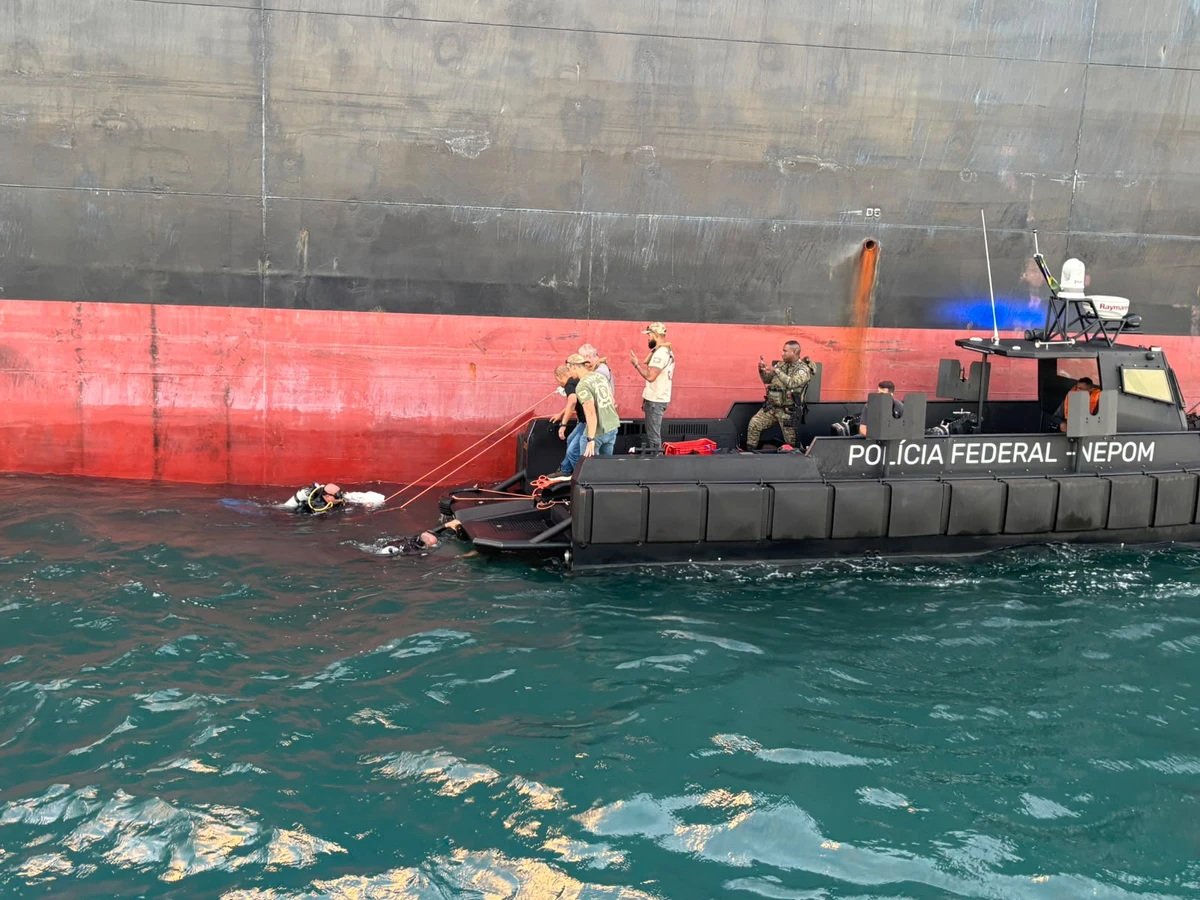 Equipe da Polícia Federal em embarcação junto ao casco de um navio durante a operação na Baía de Todos-os-Santos.