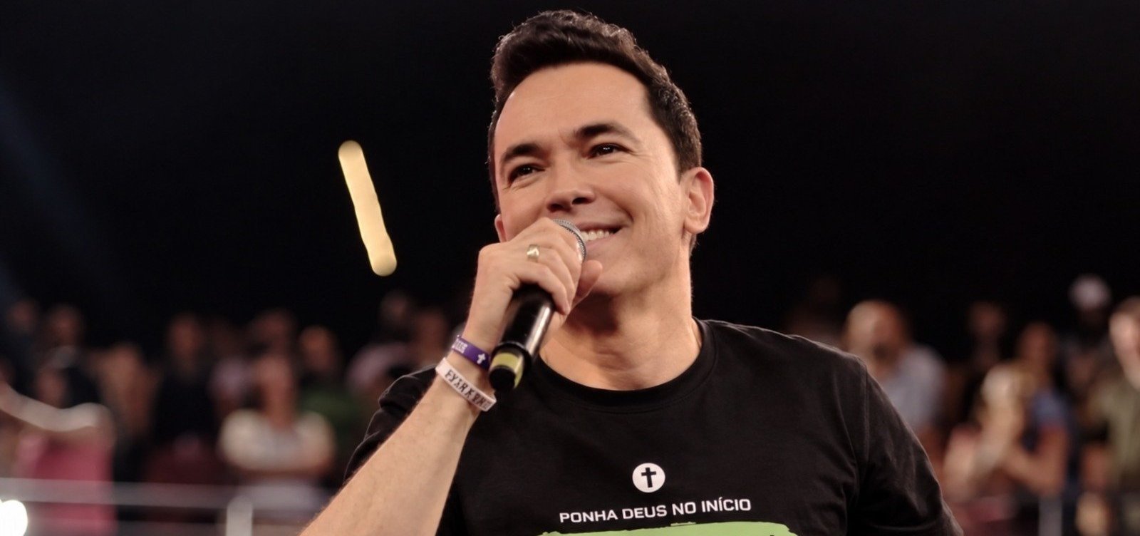 Pastor Lucinho segura microfone durante uma pregação