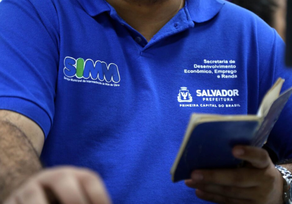 Profissional do Simm de Salvador segura uma carteira de trabalho